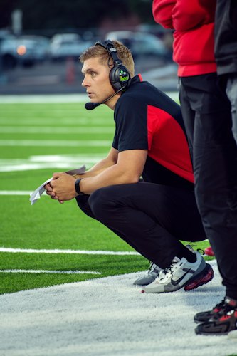 Physical therapist assessing an athlete's leg movement during a recovery evaluation