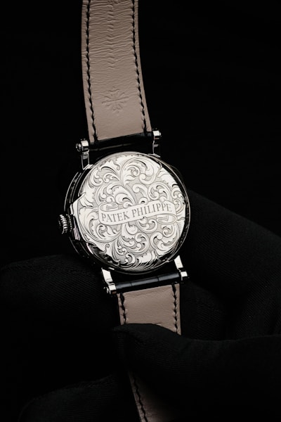 a silver watch on a black surface