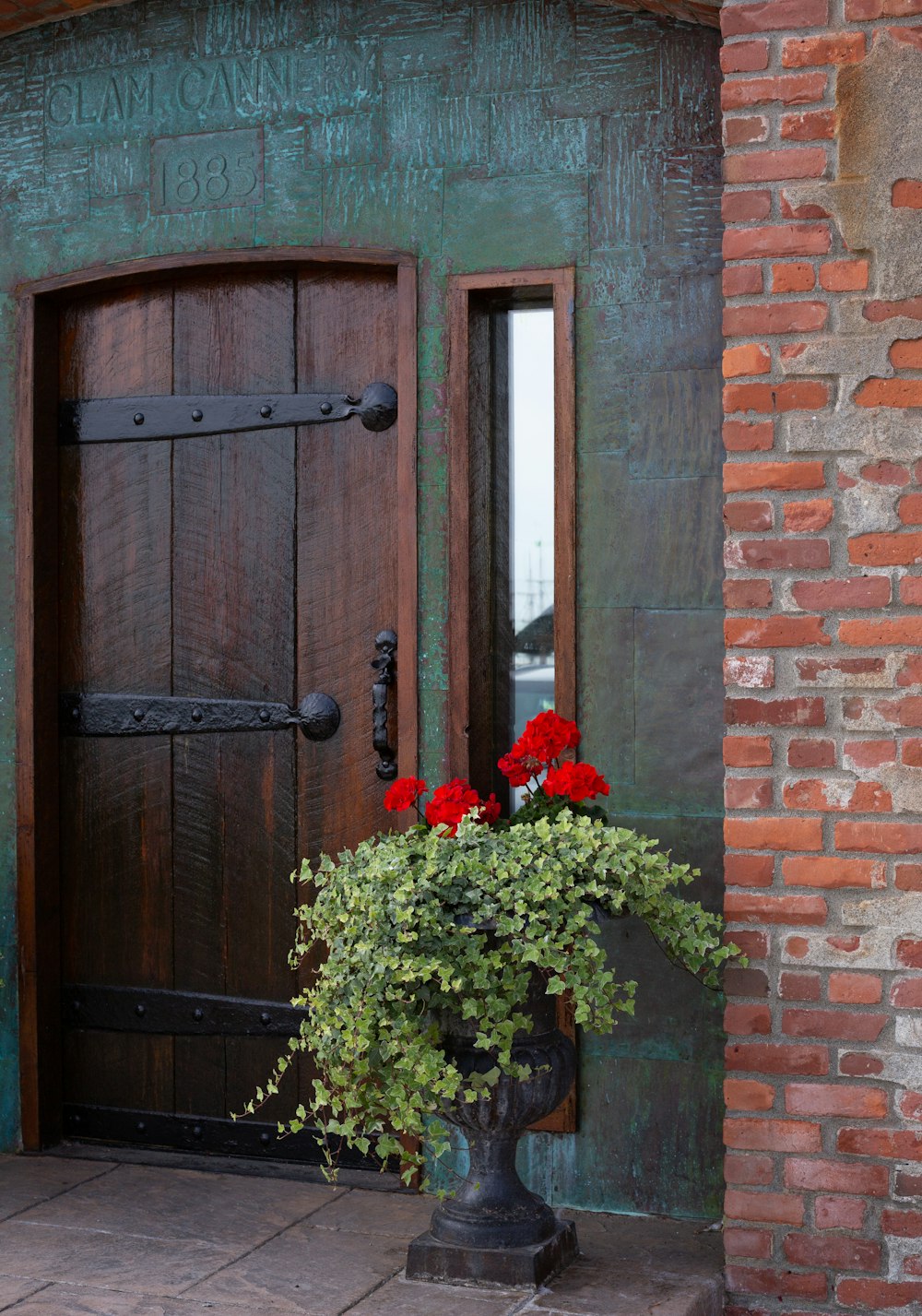 uma porta com um vaso de flores na frente dela