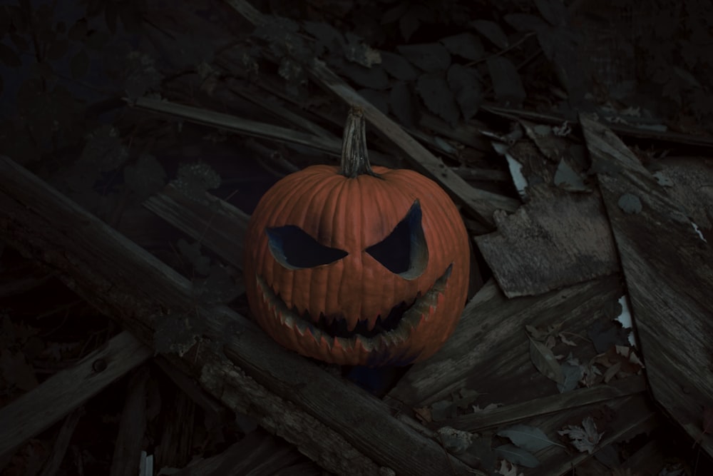 a carved pumpkin on a log