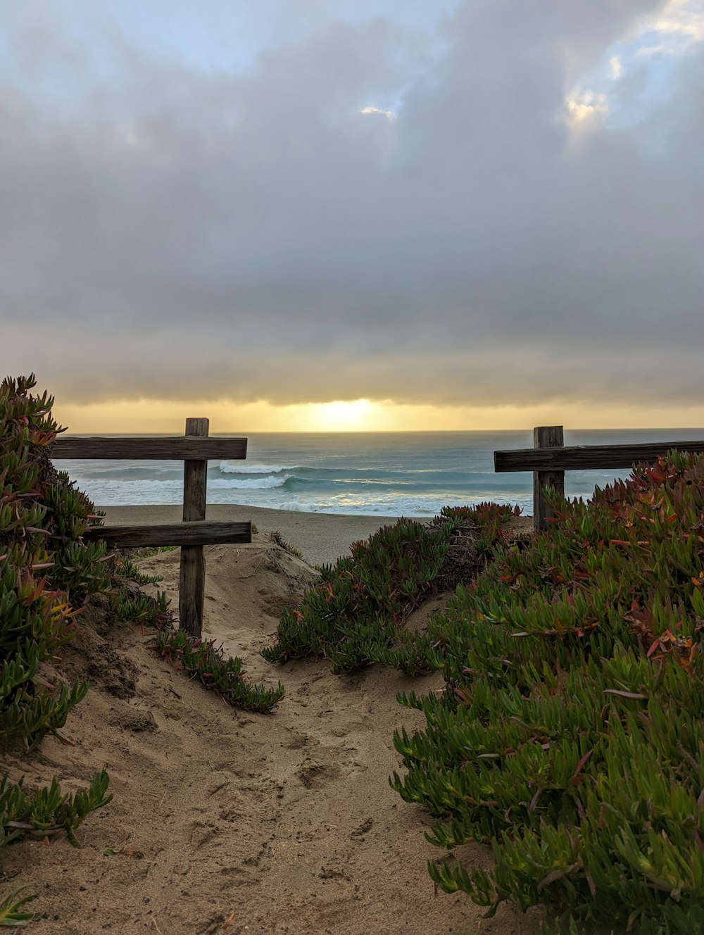 a beach with a bench and a body of water