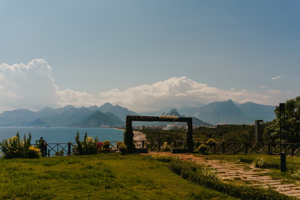 a grassy area with a body of water in the background