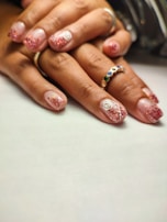 Close-up of elegant nail designs featuring gel polish in soft pink tones.