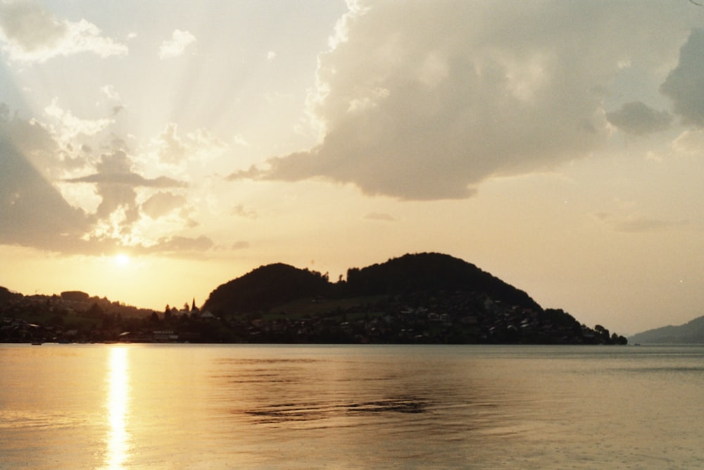 a body of water with a hill in the background