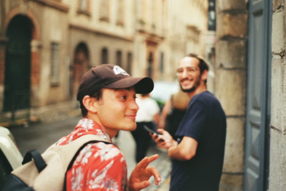 a person in a baseball cap pointing at a person in a hat