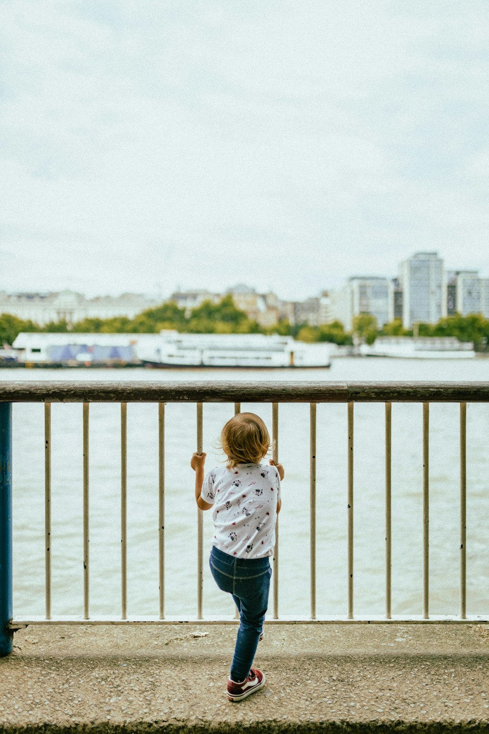 uma criança em pé em uma ponte