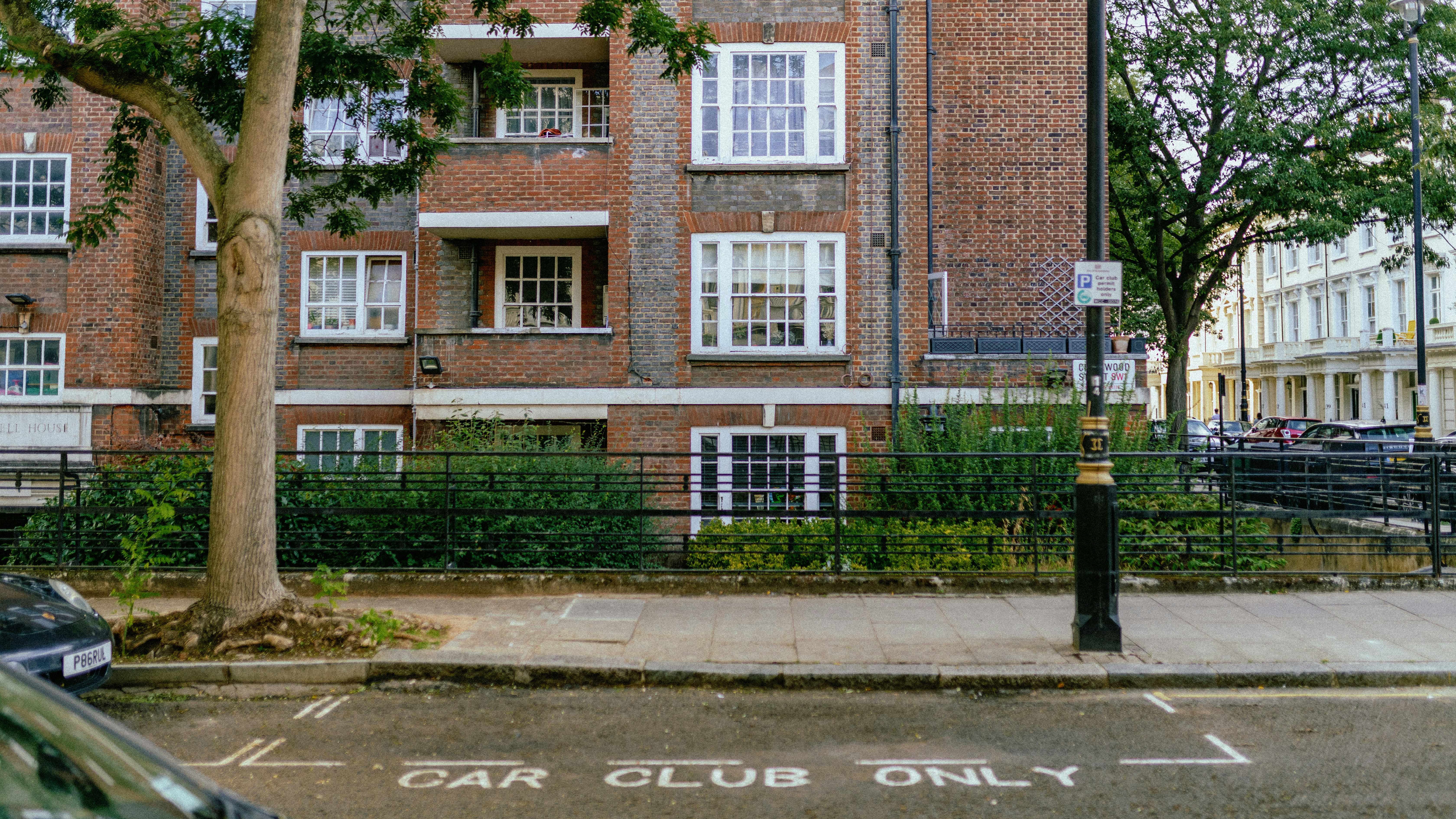 a street with a brick building and trees