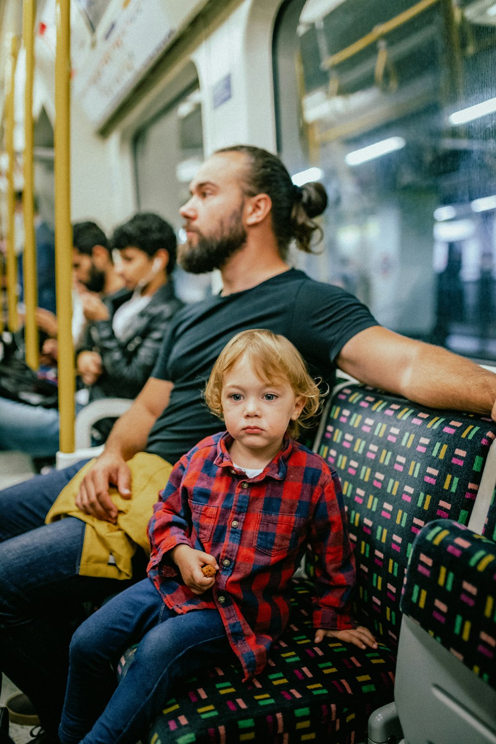 a person and a child sitting on a bus