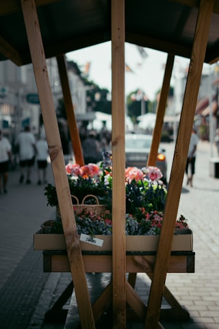 Close-up of a stylish Seven Cart kiosk decorated with fresh flowers at a city fair.