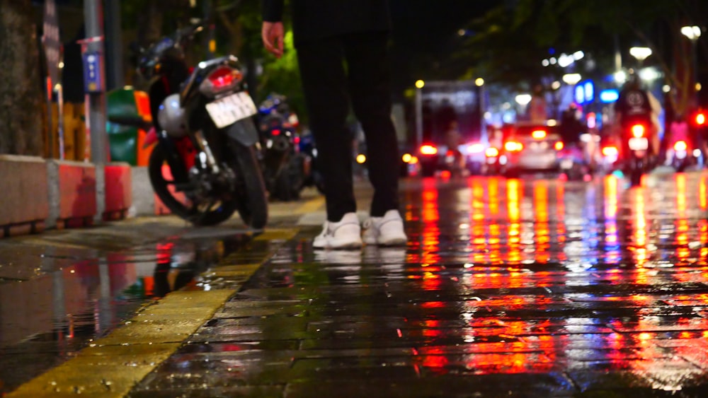 Una persona parada en una calle mojada