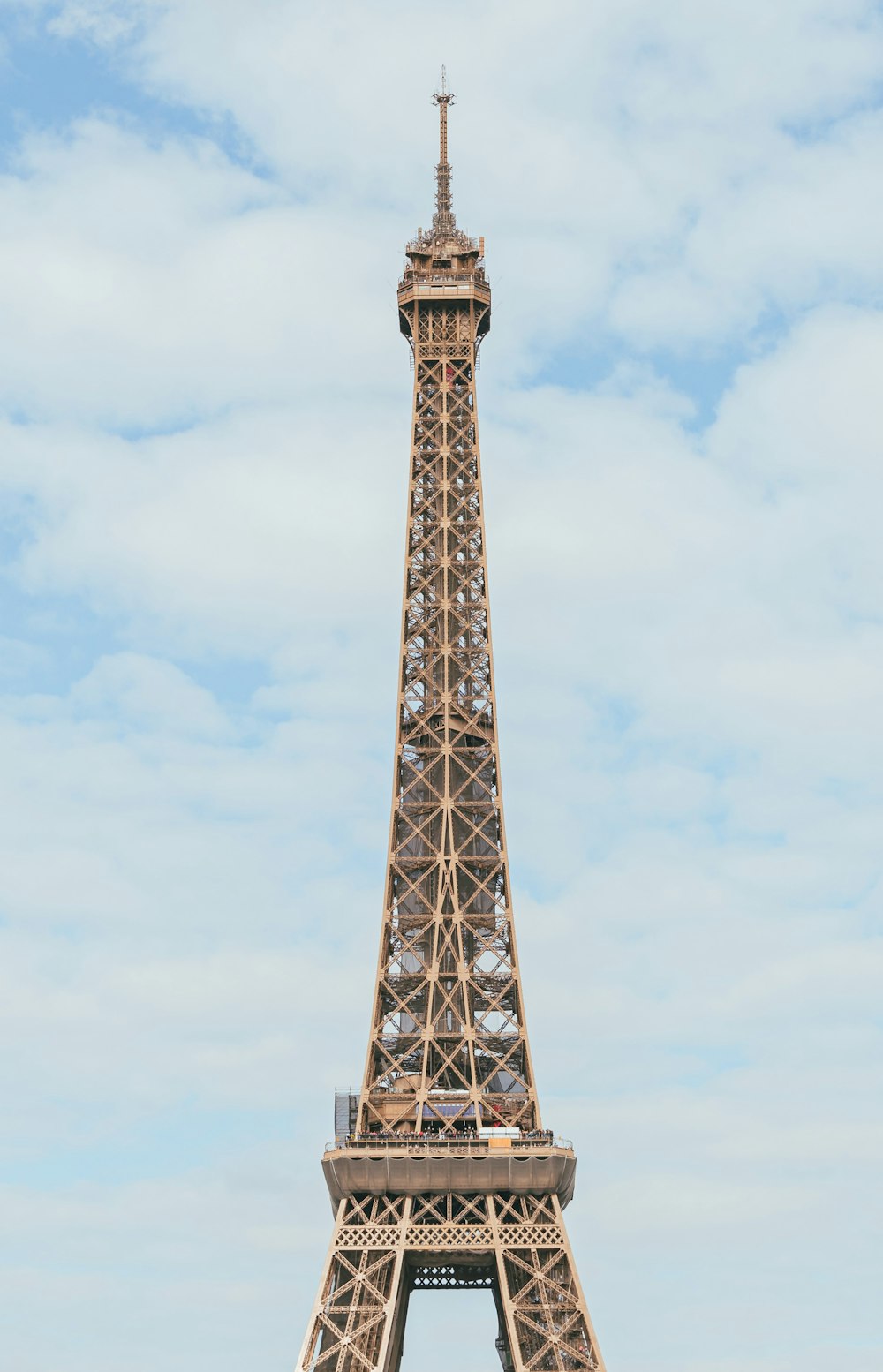 a tall metal tower with Eiffel Tower in the background