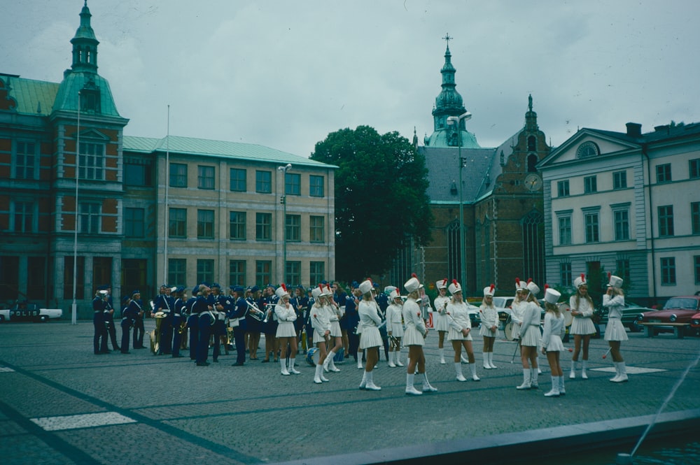 a group of people in white marching in a parade