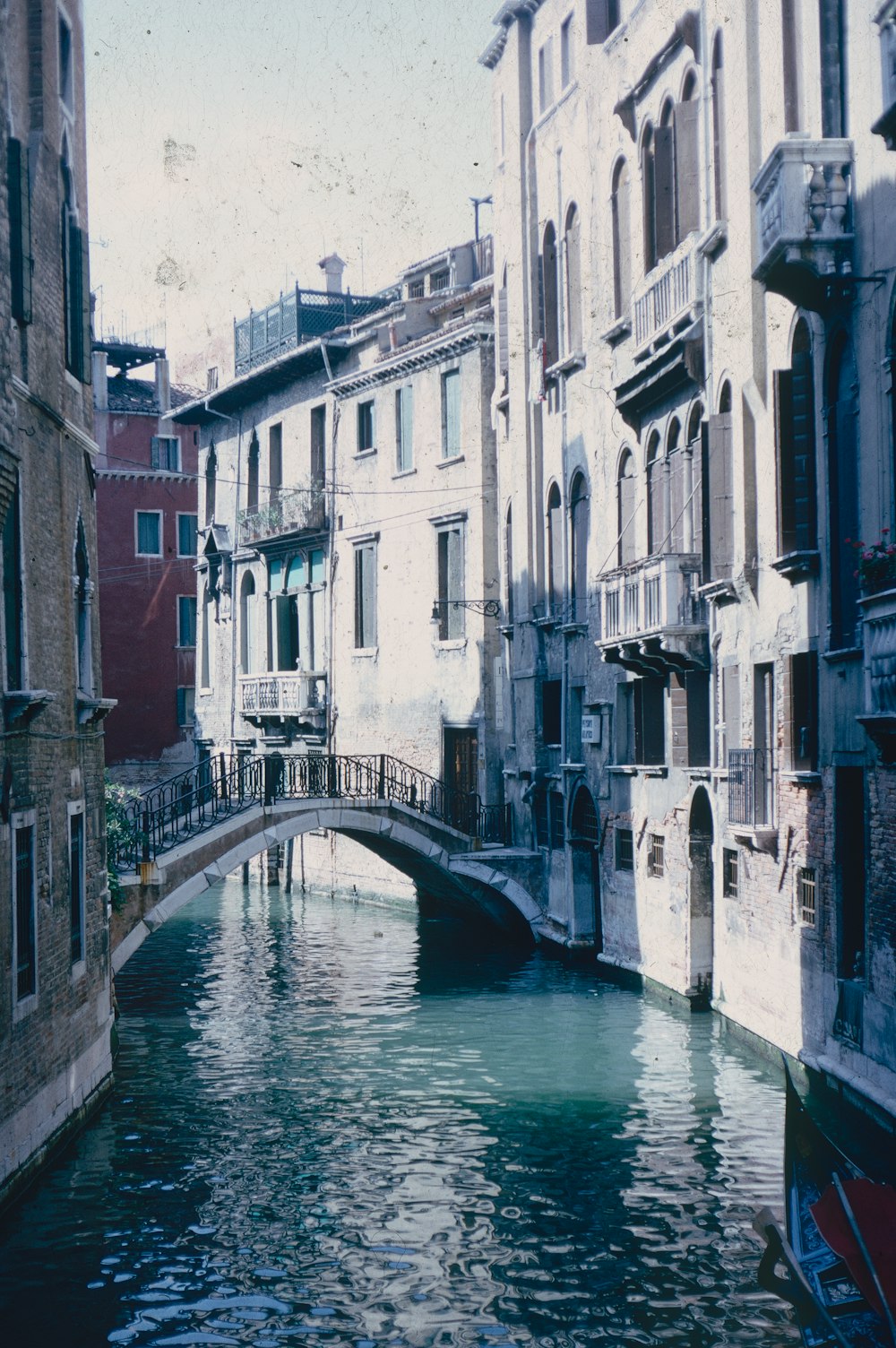 a bridge over a canal between buildings