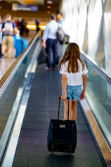 a person with a suitcase walking down a conveyor belt