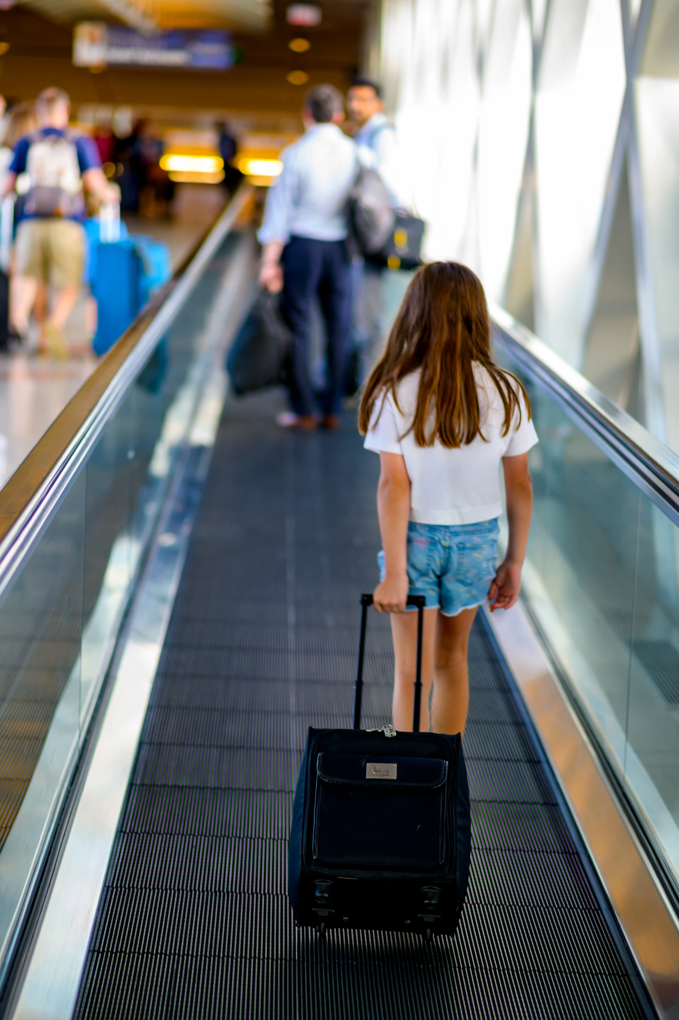 Traveler moving through an airport with rolling luggage