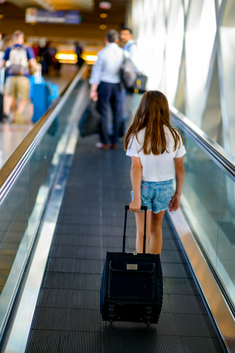 a person with a suitcase walking down a conveyor belt