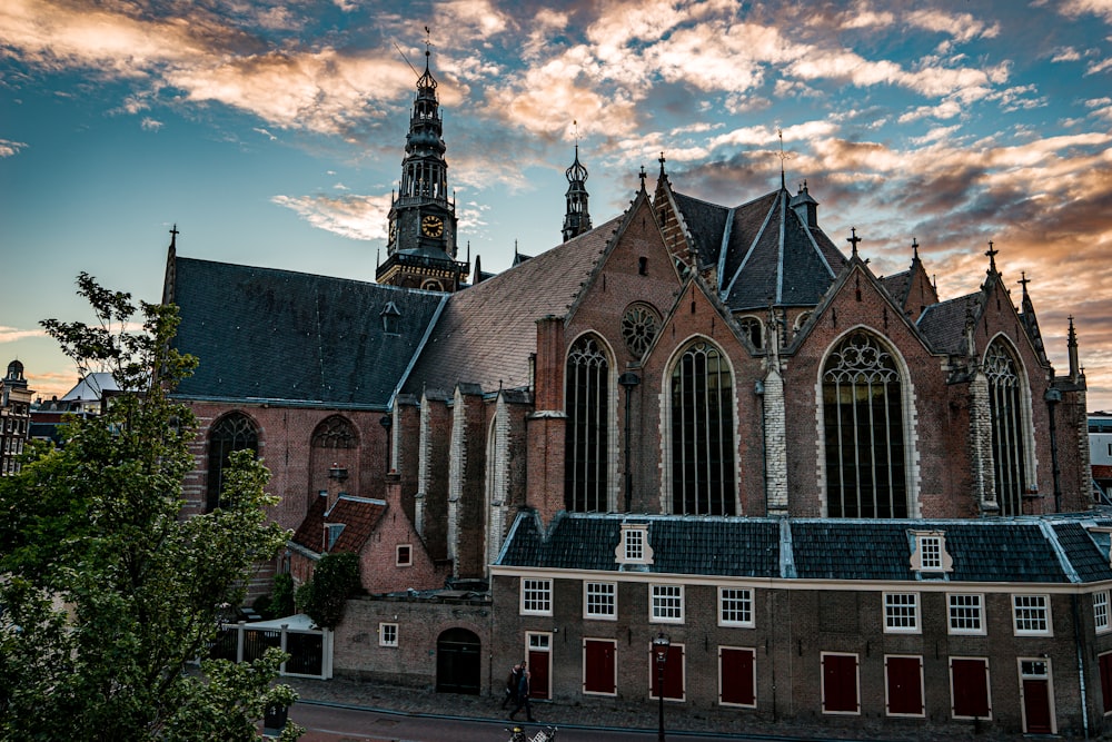 un gran edificio con una torre del reloj con Oude Kerk al fondo