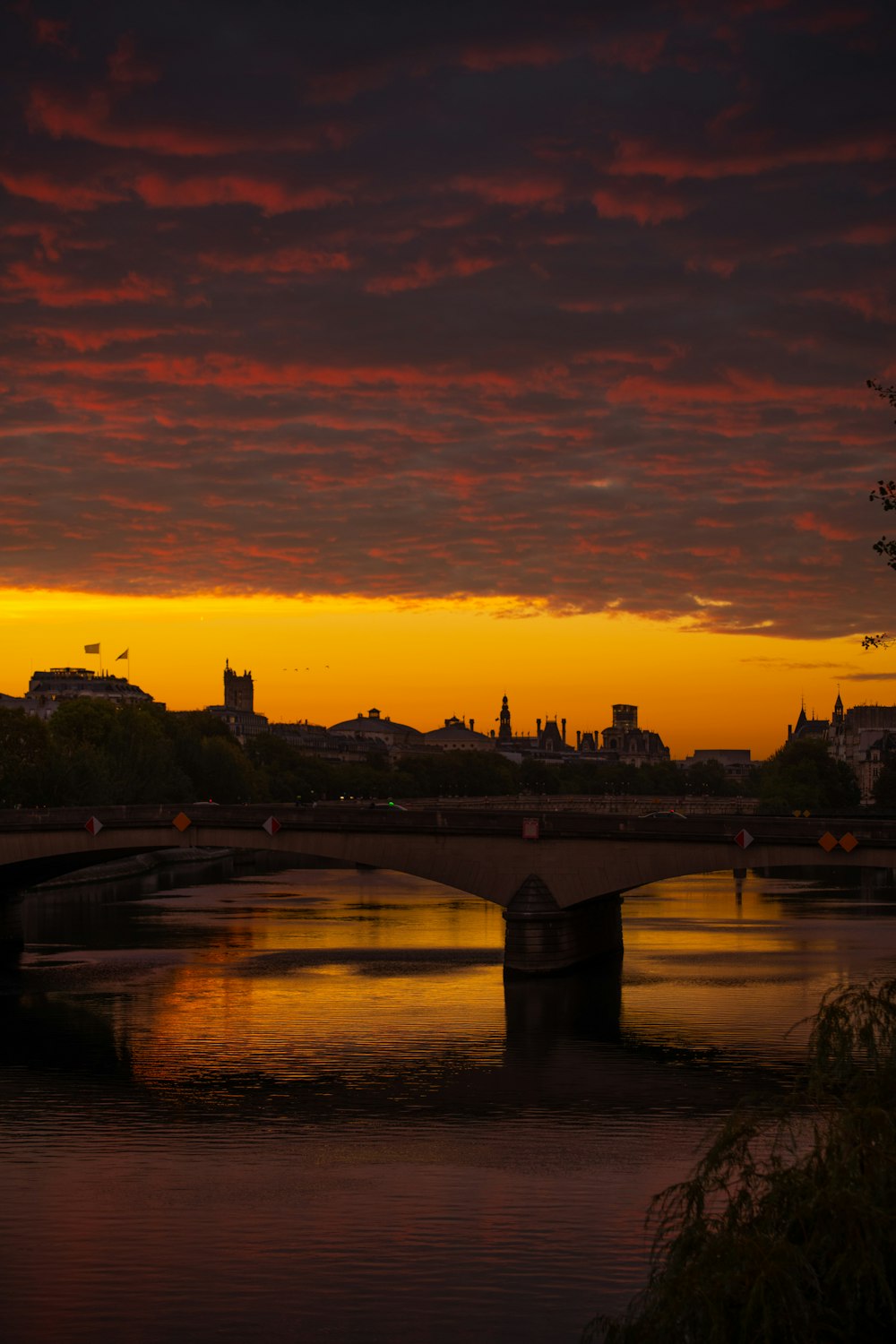 a bridge over a river with a city in the background