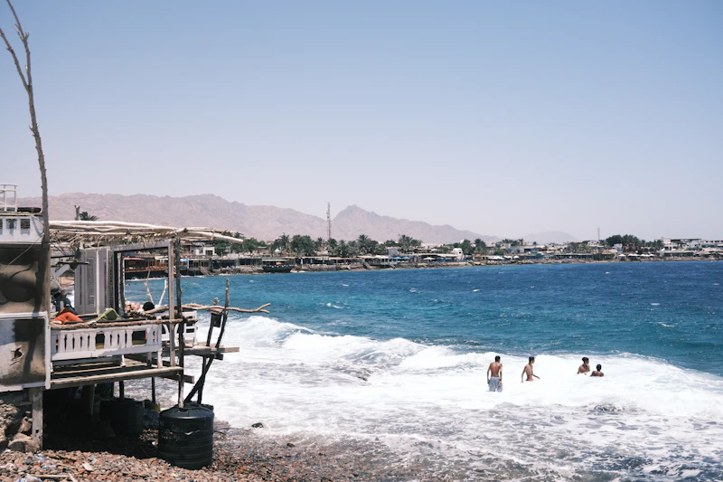 People relaxing by the clear sea in Dahab
