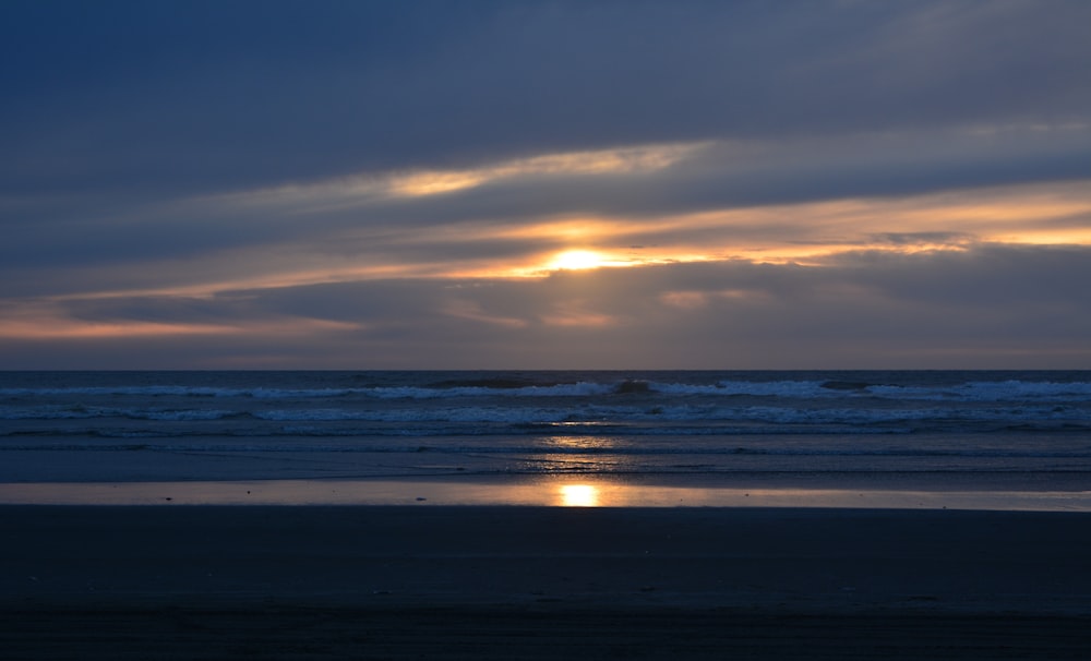 uma praia com um pôr do sol