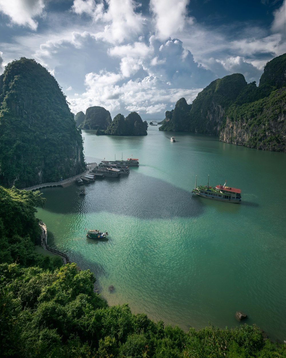 a group of boats on a body of water surrounded by mountains