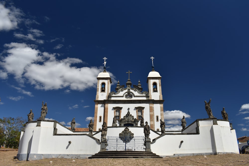 a white building with statues and a blue sky