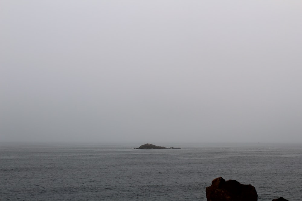 a large body of water with a small island in it