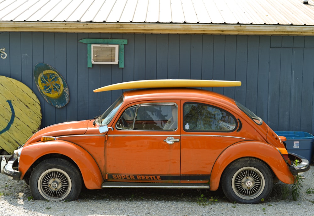 Foto Um carro laranja com uma prancha de surf em cima dele – Imagem de Loja  de praia do Joe Louco grátis no Unsplash