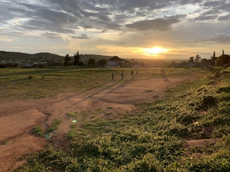 A group of players strategizing together in a rugged post-apocalyptic landscape at sunset.