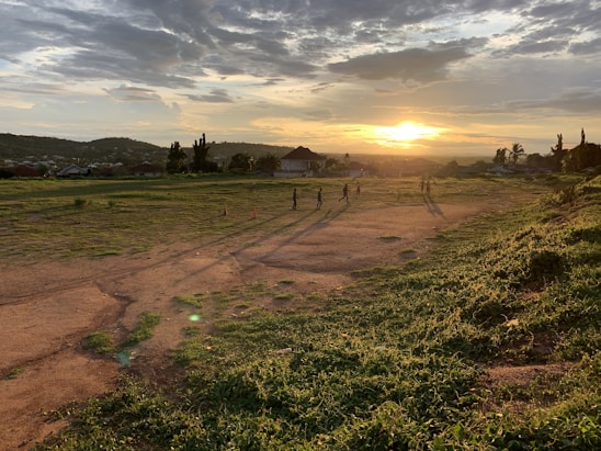 A group of players strategizing together in a rugged post-apocalyptic landscape at sunset.