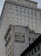 A tall building with an intricate architectural design and a large advertisement painted on one of its walls for the Commercial Union Assurance Company. The facade features numerous windows in a symmetrical pattern, and the structure has a historic, early 20th-century appearance.