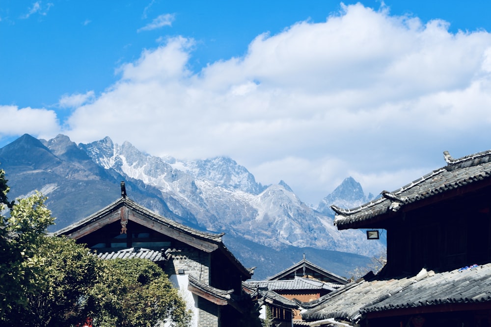 a group of buildings with snow covered mountains in the background