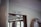 A sign reading 'Salon - 2. Klasse' is mounted above a doorway with wooden trim. The area is inside a ship, indicated by the life preserver hanging on the wall nearby. Soft natural light enters through windows, highlighting the interior maritime decor.