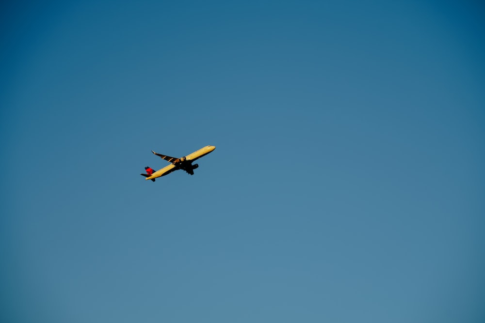 Ein gelbes Flugzeug fliegt am Himmel
