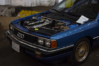 Professional mechanic using advanced diagnostic equipment on an Audi engine.