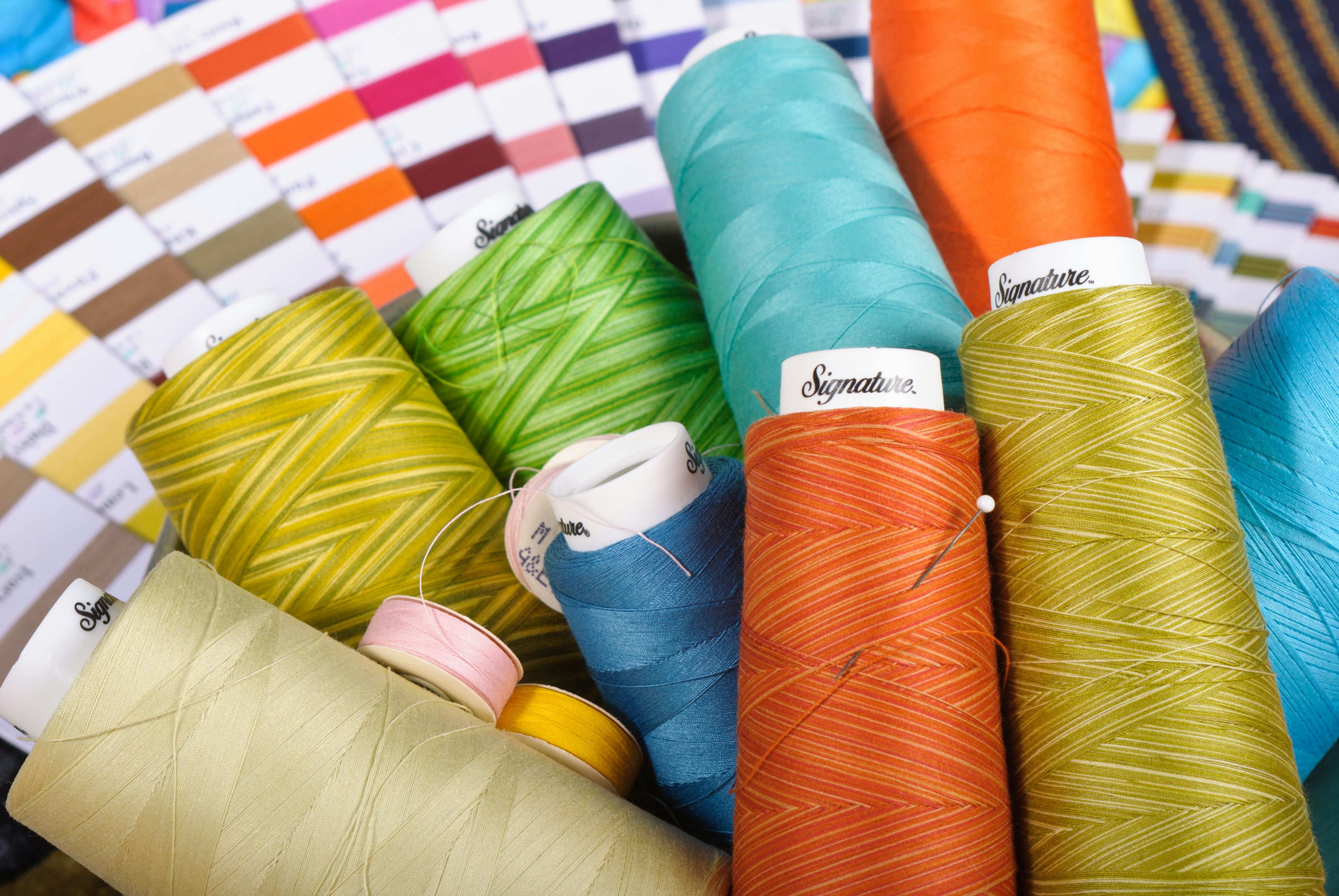 Sewing, quilting, and embroidery threads with swatches.