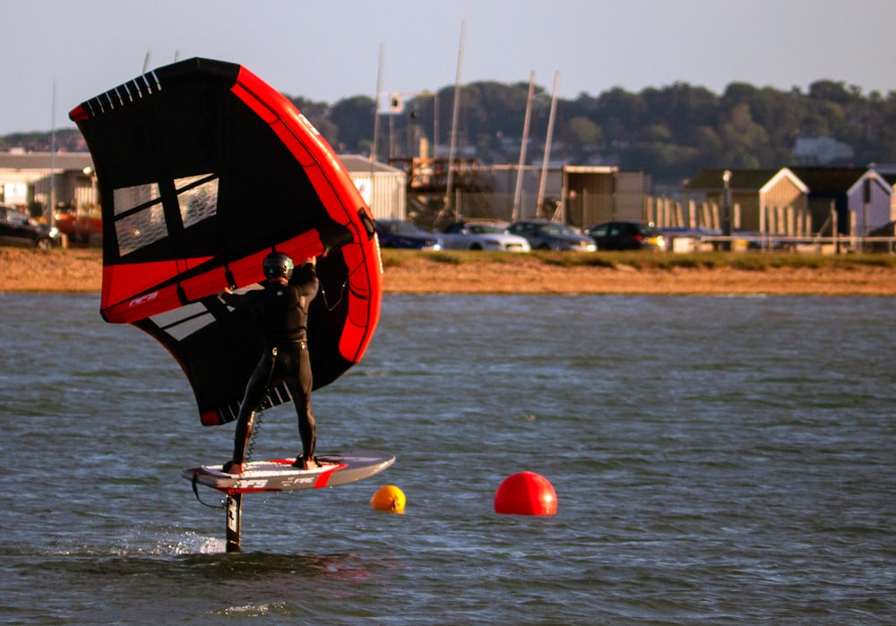 a man on a surfboard holding a sail