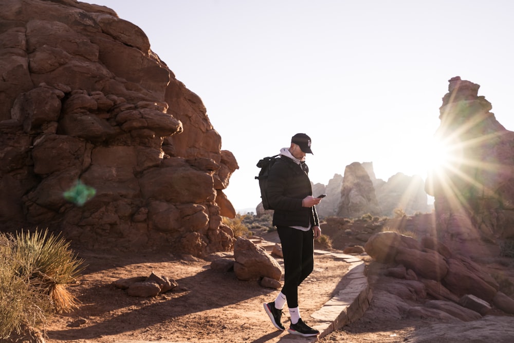 a man walking on a path with a fire in the background