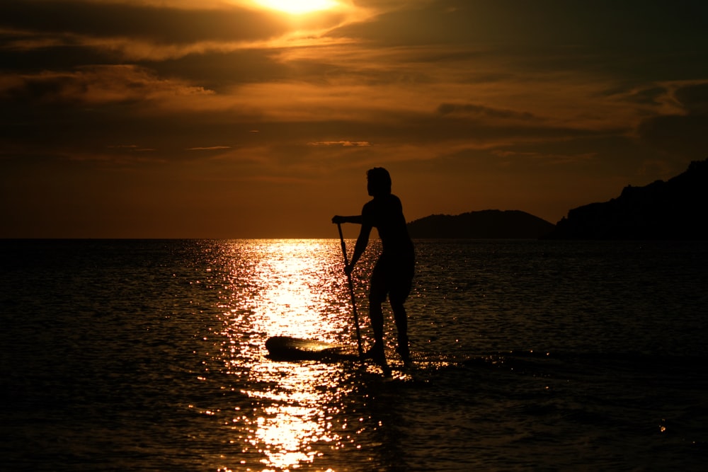 a person standing in water holding a fishing pole