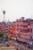 A vibrant market street in Jaipur, India, featuring traditional Rajasthani architecture with pink and red buildings illuminated by warm lighting. The street is bustling with people, vehicles, and shops creating an energetic urban atmosphere.