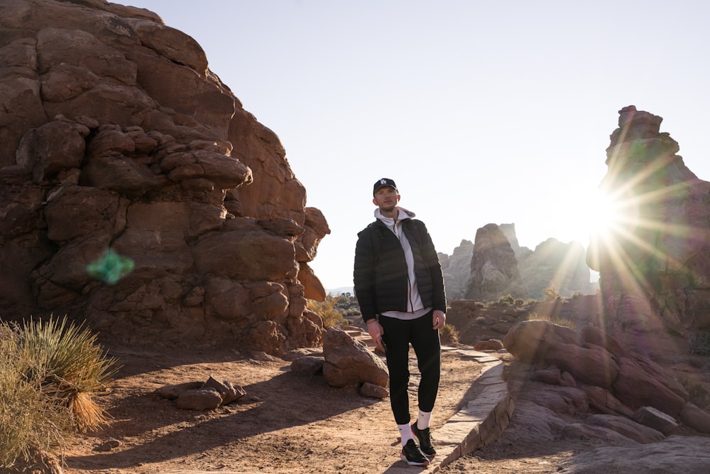 a man standing in front of a rock formation