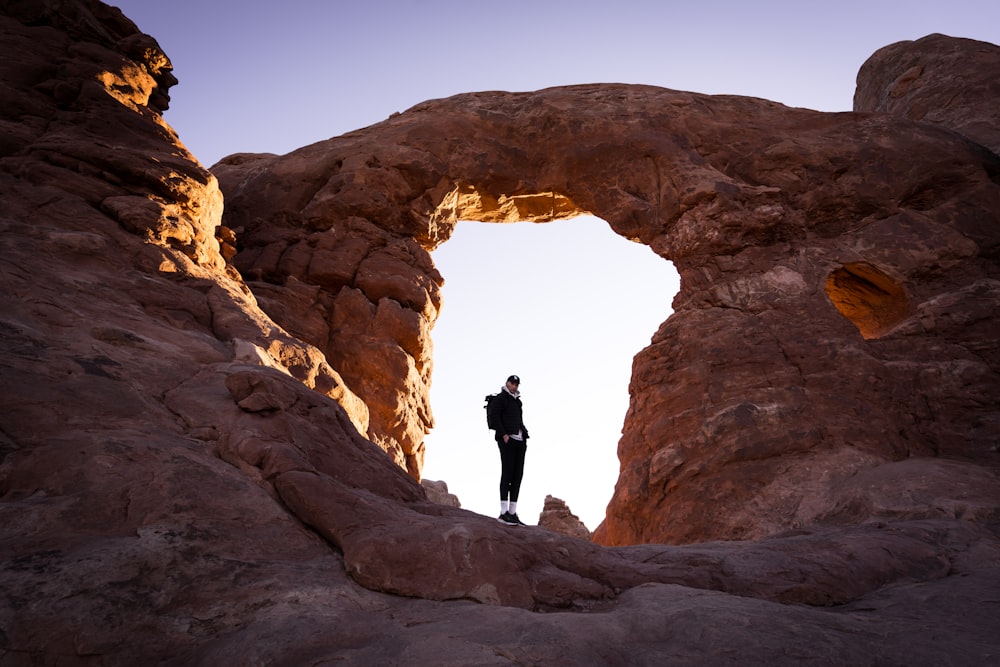 a person standing in a large rock cave