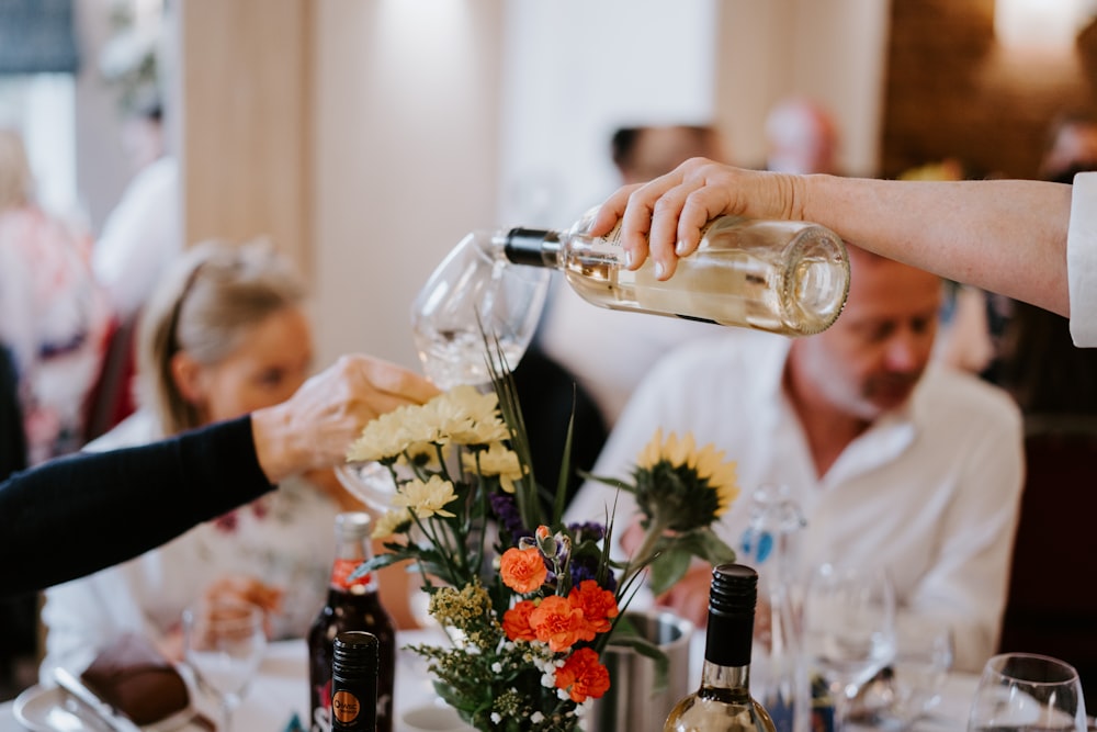 a person pouring wine into a glass