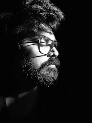 Before and after side-by-side image showing a man's transformation with precise haircut and beard styling under cinematic golden lighting.