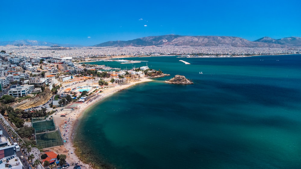 Ein Strand mit blauem Wasser und eine Stadt auf der anderen Seite