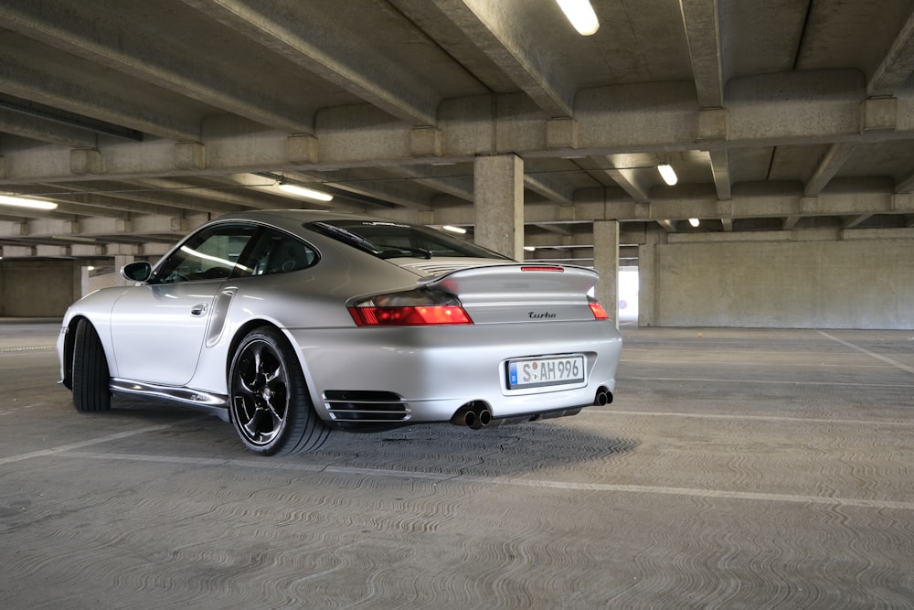 a silver sports car parked in a parking garage