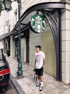 A stylish model wearing a kervstar t-shirt in a vibrant outdoor setting.