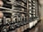 A well-organized wine cellar with rows of wine bottles stored horizontally on wooden racks. The bottles have elegant labels, indicating different varieties and vintages. The setting is dimly lit, suggesting a sophisticated, serene atmosphere typically associated with wine storage.