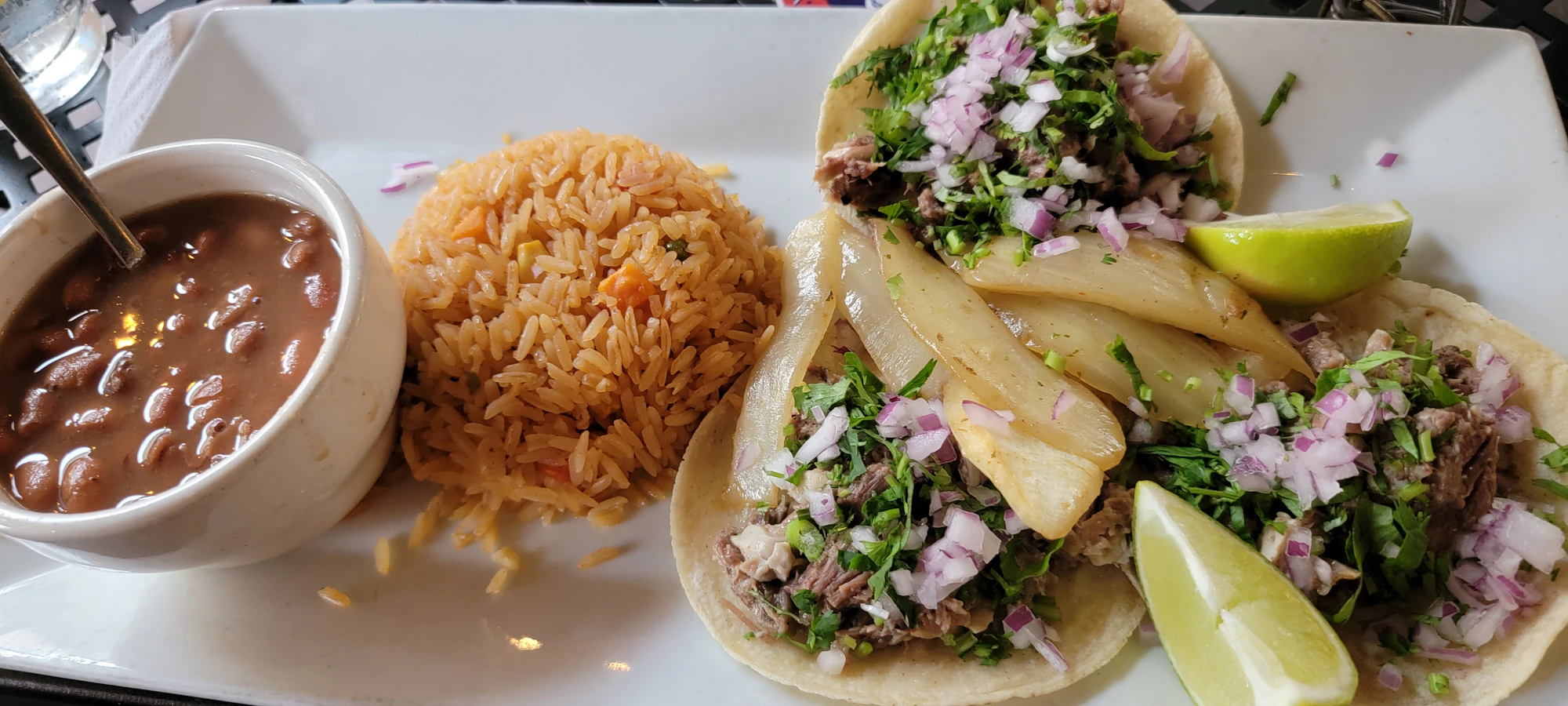 A plate of tacos topped with cilantro and onion