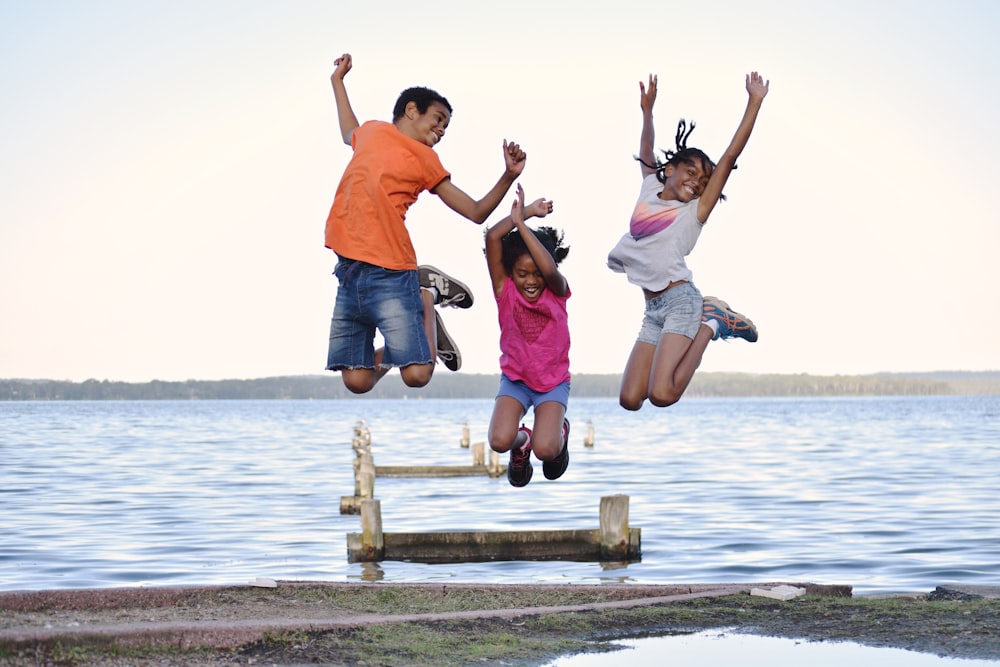 a group of people jumping on a dock